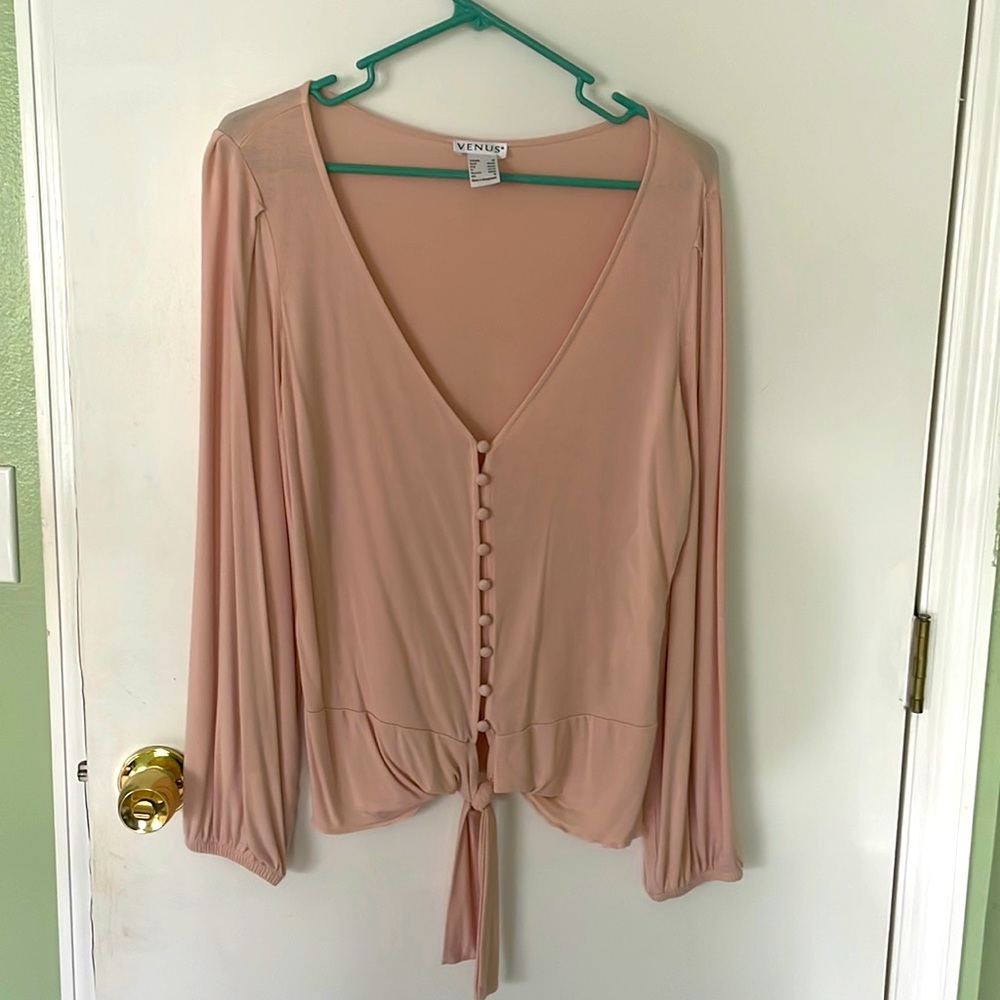 Venus, long sleeve, light pink button down top that ties at the bottom.